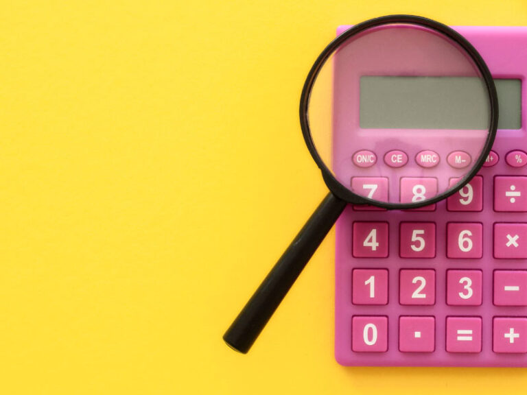 Magnifying glass on top of a pink calculator and yellow background - 4 Easy Ways to Refinance Your Home Loan