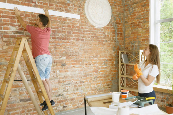 Young couple decorating their new beautiful house - DG Pinnacle Home Loans - 203k Mortgage Loan - Miami Mortgage Company