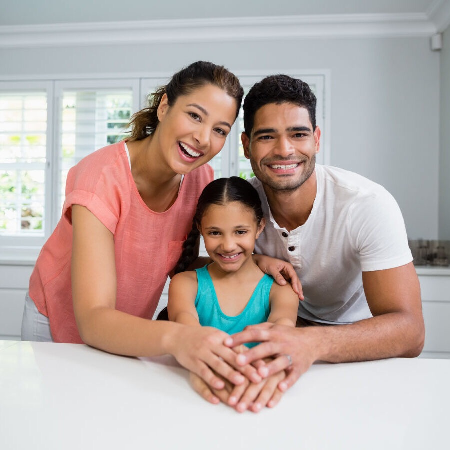Parents and daughter standing together in kitchen - DG Pinnacle Home Loans - Miami Mortgage Company