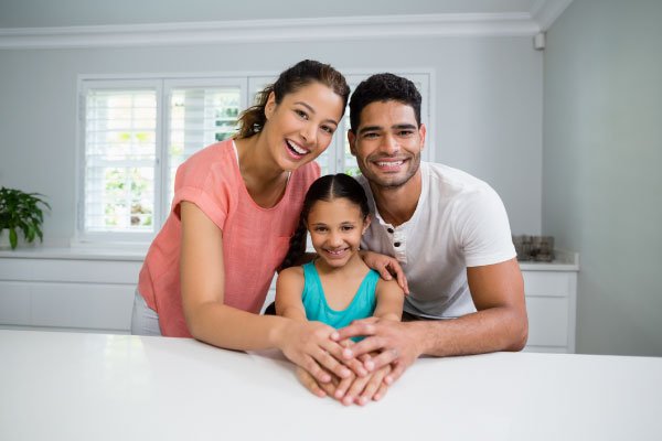 Parents and daughter standing together in kitchen - DG Pinnacle Home Loans - Miami Mortgage Company