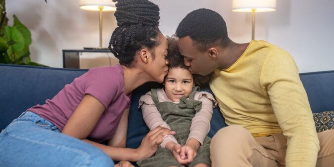 Happy millennial parents with their daughter at home - DG Pinnacle home loans