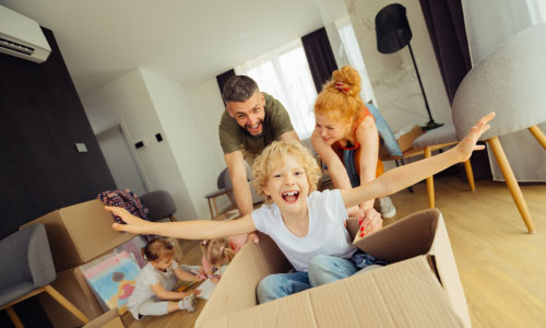 Happy millennial parents playing their kids at home - DG Pinnacle home loans