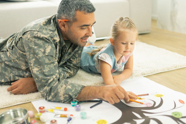 Soldier and his daughter laying on the floor and drawing family tree together - DG Pinnacle Home Loans - VA Loans - Miami Mortgage Company