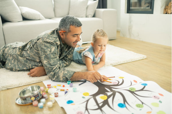 Soldier and his daughter laying on the floor and drawing family tree together - DG Pinnacle Home Loans - VA Loans - Miami Mortgage Company