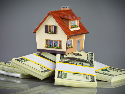 Concept of cash-out refinance with a model house on packs of banknotes- DG Pinnacle Home Loans - Miami Mortgage Lender