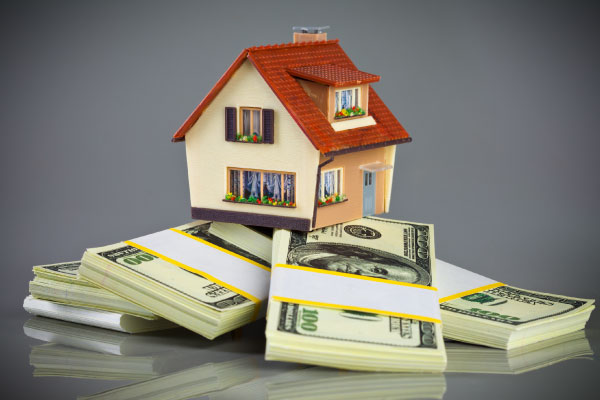 Concept of cash-out refinance with a model house on packs of banknotes- DG Pinnacle Home Loans - Miami Mortgage Lender