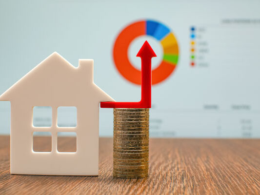 Concept photo of increasing prices for real estate market and a model house with some coins - DG Pinnacle Home Loans - Miami Mortgage Lender