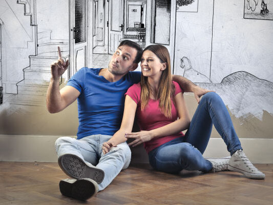 Young couple sitting together and planning decoration for their new home - 5 steps for getting your mortgage pre-approved - DG Pinnacle Home Loans - Miami Mortgage Lender