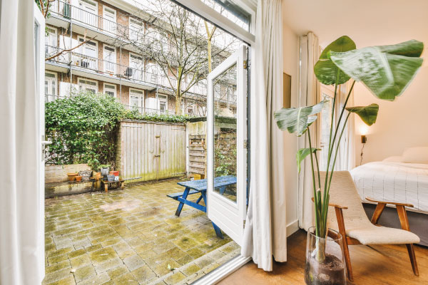 General view of a backyard with tiled floor and some apartments - 5 benefits of buying a home - DG Pinnacle Home Loans - Miami Mortgage Lender