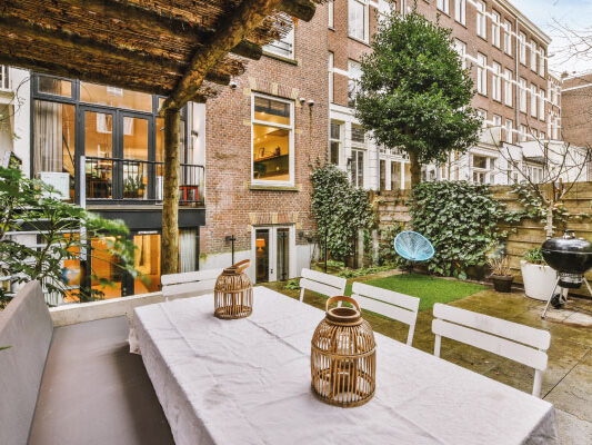 General view of a backyard with tiled floor and dining area under canopy - 5 benefits of buying a home - DG Pinnacle Home Loans - Miami Mortgage Lender