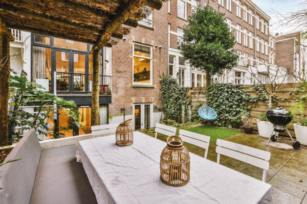 General view of a backyard with tiled floor and dining area under canopy - 5 benefits of buying a home - DG Pinnacle Home Loans - Miami Mortgage Lender