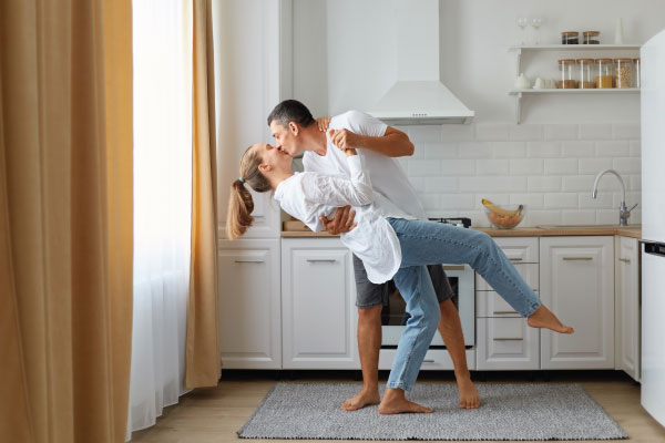 Happy couple dancing together in kitchen - Understanding and using the FHA Loan - DG Pinnacle Home Loans - Miami Mortgage Lender