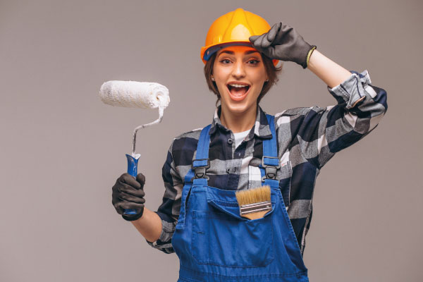 Repairer woman with painting roller and helmet | Renovation Mortgages - FHA 203K loans | DG Pinnacle Home Loans - Miami Mortgage Lender
