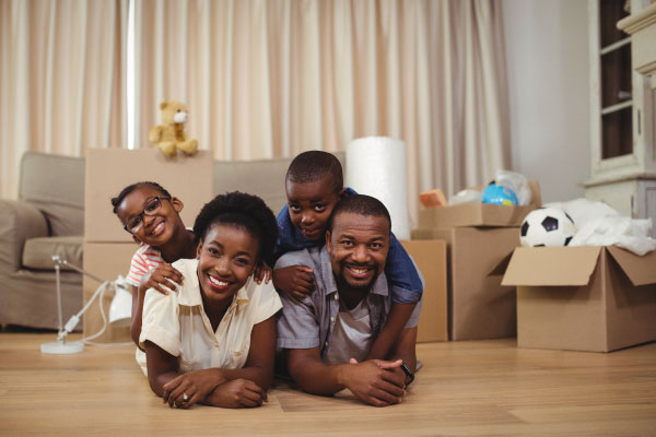 Happy family lying on top of each other on the floor - Top 7 Tax Benefits of Owning a Home - DG Pinnacle Home Loans - Miami Mortgage Lender