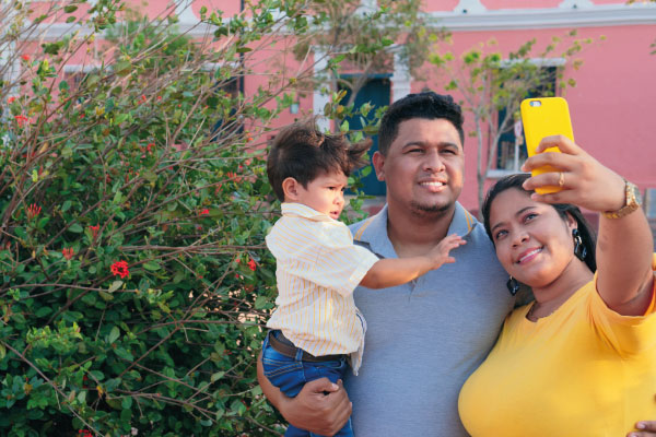 Latin family taking selfie in the park | Do You Have to Be a U.S. Citizen to Get a Mortgage? | DG Pinnacle Home Loans - Miami Mortgage Lender
