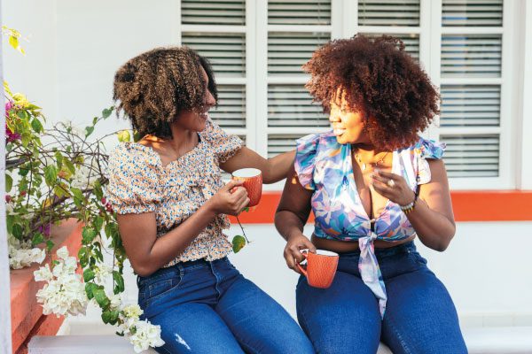 Two latin women having a cup of coffee on the porche | Do You Have to Be a U.S. Citizen to Get a Mortgage? | DG Pinnacle Home Loans - Miami Mortgage Lender