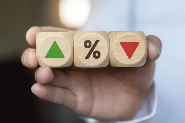 Businessman holding wooden cube blocks with percentage symbols - Will Rates Go Down in July 2023? | DG Pinnacle Home Loans | Miami Mortgage Funding Lender