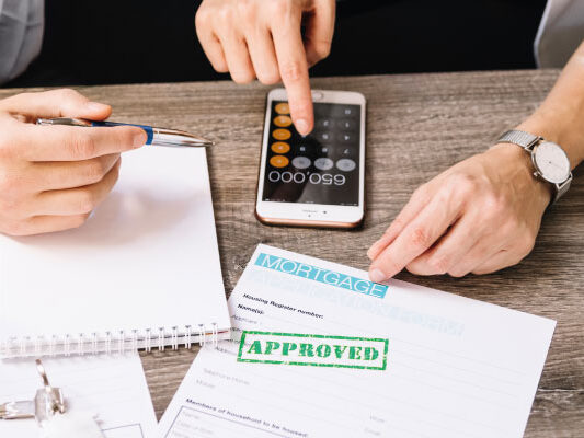 Mortgage broker and client checking some documents | Mortgage rates fall below 7% | DG Pinnacle Home Loans - Miami Mortgage Lender