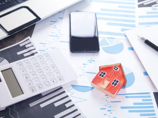 Model house and calculator with mortgage documents | Mortgage rates fall below 7% | DG Pinnacle Home Loans - Miami Mortgage Lender