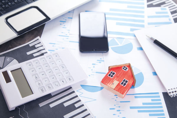 Model house and calculator with mortgage documents | Mortgage rates fall below 7% | DG Pinnacle Home Loans - Miami Mortgage Lender