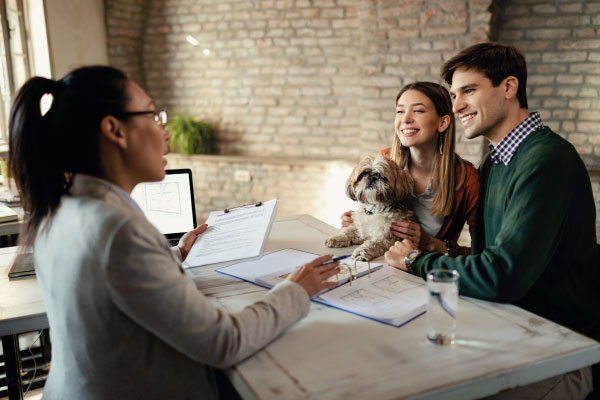Female mortgage officer at office talking to a couple with a puppy - What is a Closed-End Second Mortgage | DG Pinnacle Home Loans | Miami Mortgage Lender