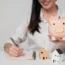 Happy woman holding piggy bank with model house | Saving for a house | DG Pinnacle Home Loans - Miami Mortgage Lender